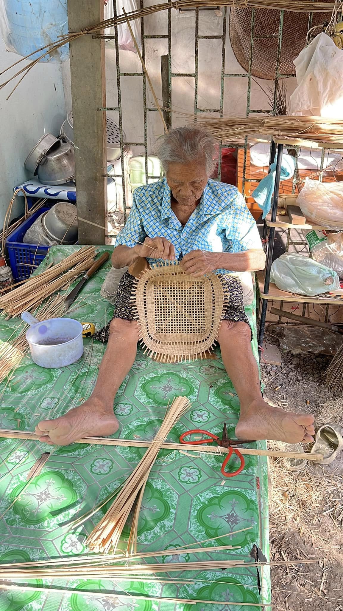 ช่างสูงวัยกำลังขึ้นรูปตะกร้าจักสาน